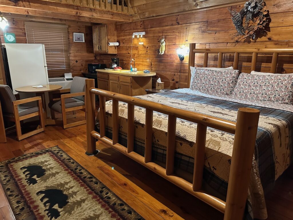 Cabin 20 accommodations and docks motel in Townsend TN with king bed showing kitchentte in the background