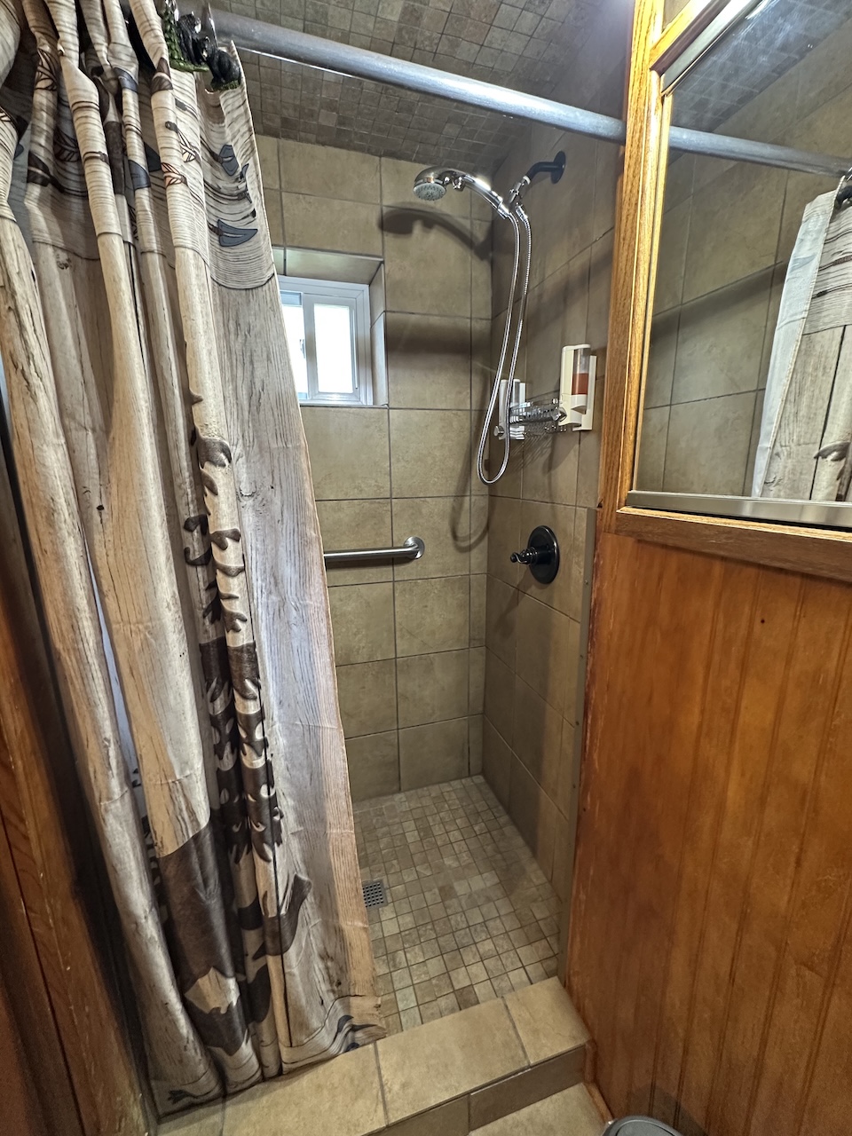 King Efficiency Suite step in shower in room 1 King Efficiency showing handheld shower and new tile
