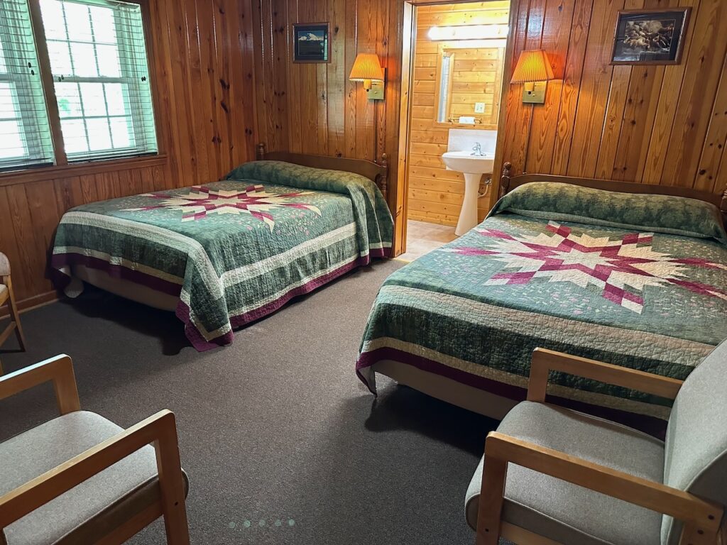bedroom 1 of Heritage Cabin showing 2 queen beds and 1/2 bath