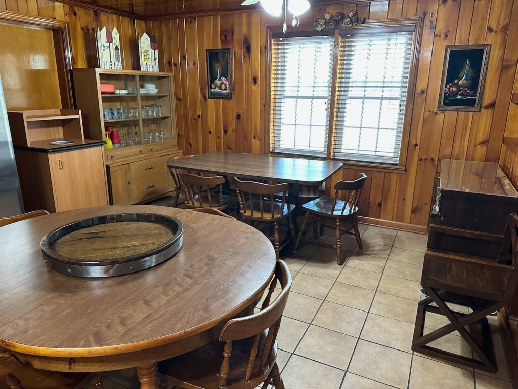 kitchen of Heritage Cabin at Docks MOtel shwoing the dining room table and a second farm style table in the background