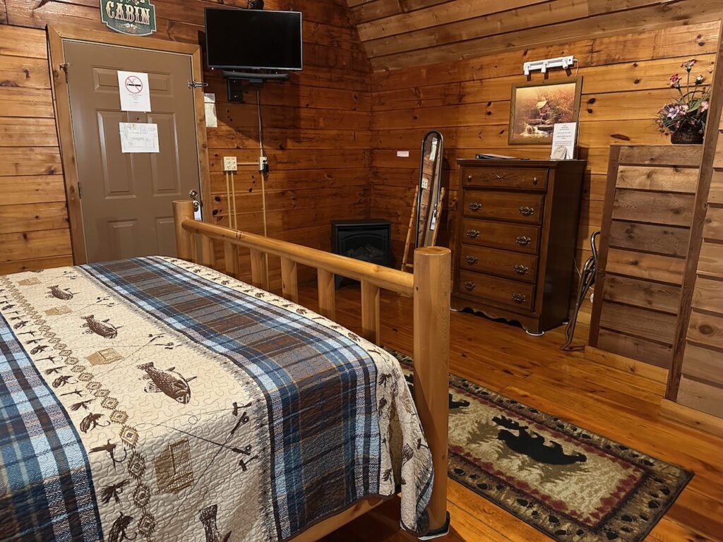 cabin 20 interior showing king bed, dresser, tv on the wall
