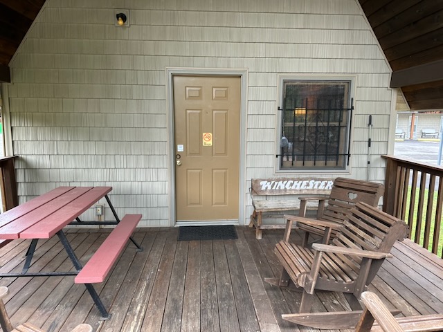 poolside cabin 23 porch with 2 rocking chairs and a picnic table