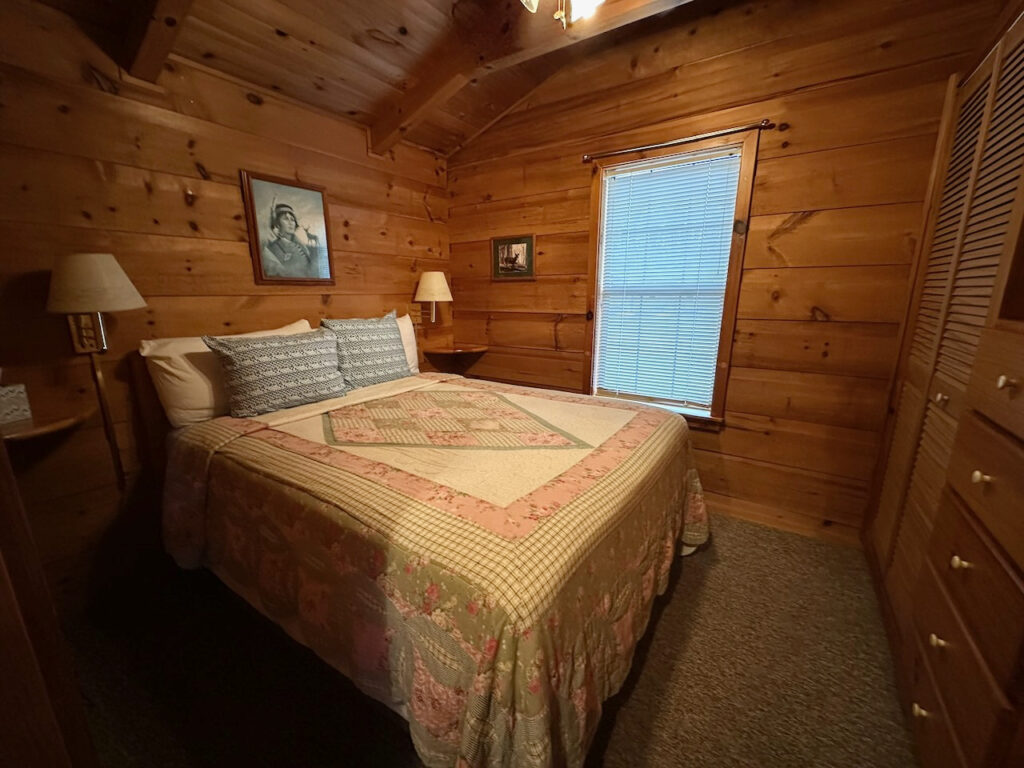 bedroom with queen bed in rendevous cabin 2 at docks motel