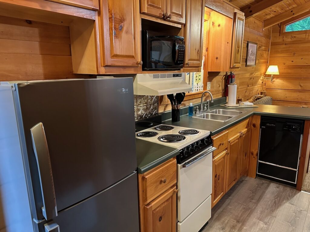 Rendevous Cabin 2 full kitchen with stove, fridge, and fully stocked kitchen cabinets