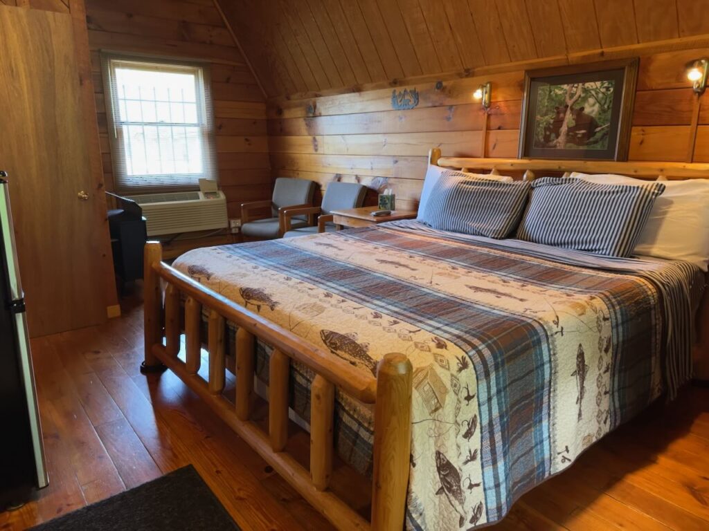 king bed in riverside cabin at docks motel showing log bedframe