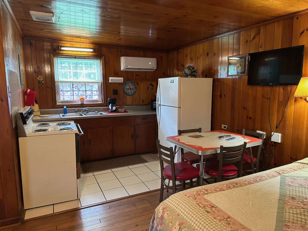 Full Kitchen with Dining Room table, stove, fridge, sink and dishes