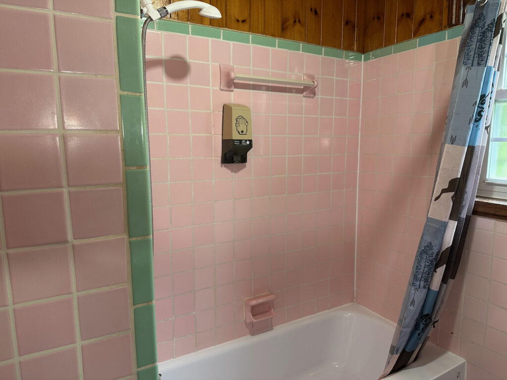 retro shower showing the pink and green vintage colors in the shower tile of the shower tub combo